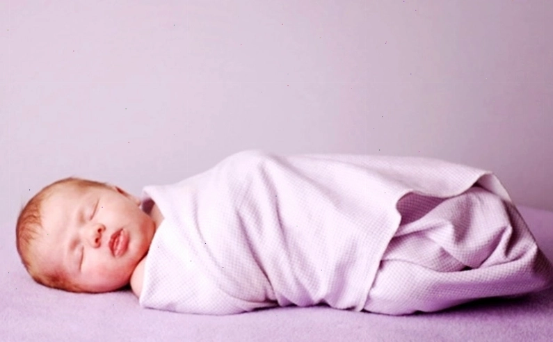 Bé sơ sinh được quấn nhẹ nhàng bằng khăn mềm