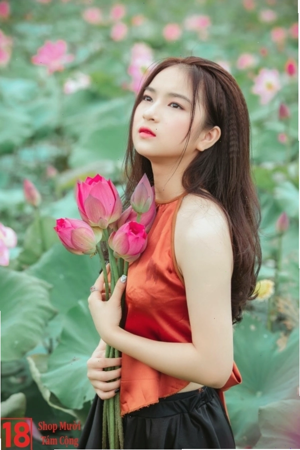 Cô gái duyên dáng trong tà áo dài cầm hoa sen trắng