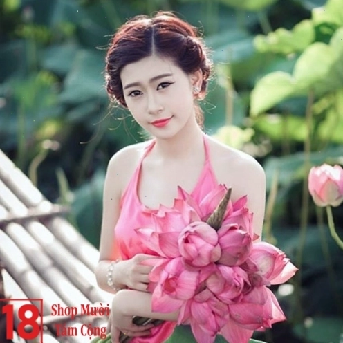 Cô gái nhẹ nhàng ngắm nhìn đóa hoa sen đang nở
