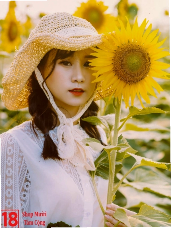 Cô gái tươi cười rạng rỡ khi cầm bó hoa hướng dương lớn