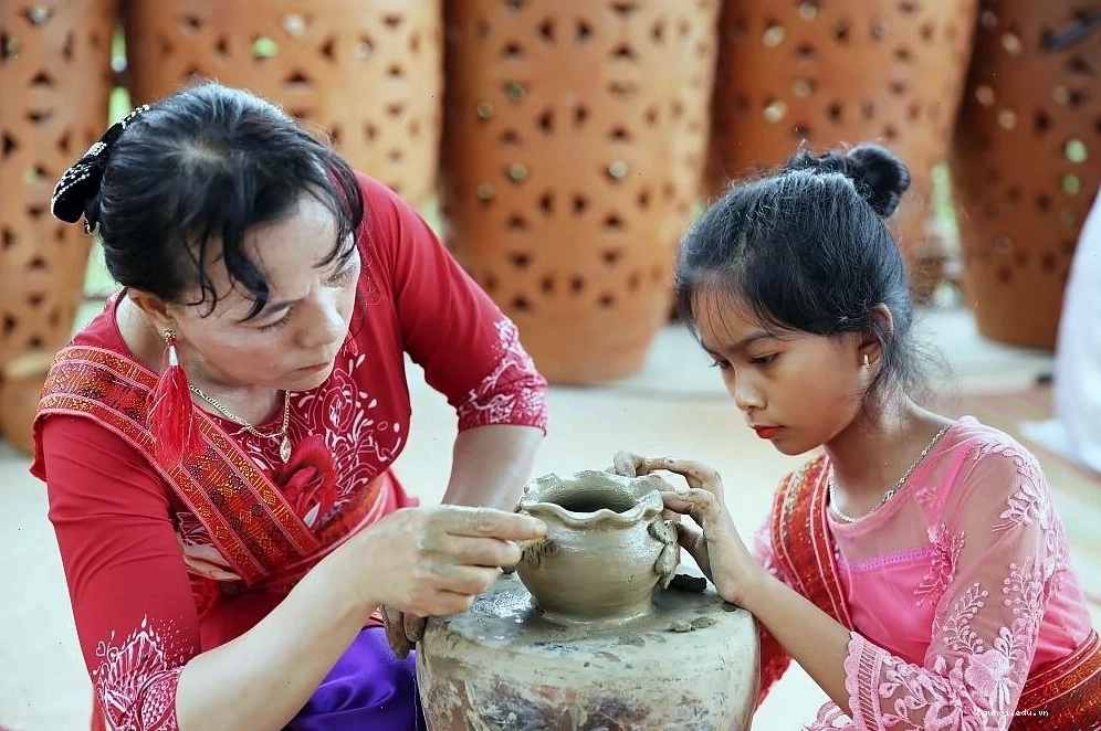 Du khách đang hào hứng tham gia trải nghiệm làm gốm tại làng Bàu Trúc