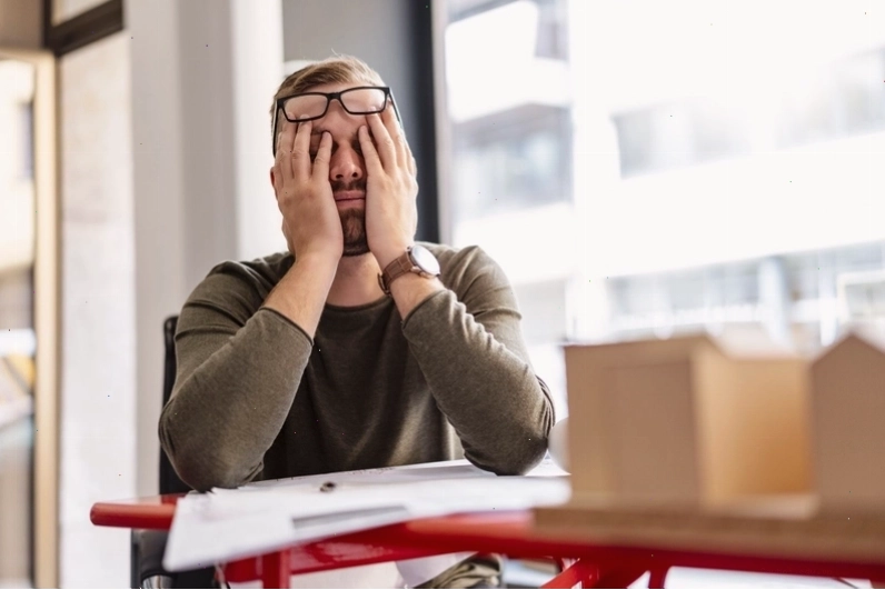 Người đàn ông ngủ gật trên bàn làm việc do thiếu ngủ trưa