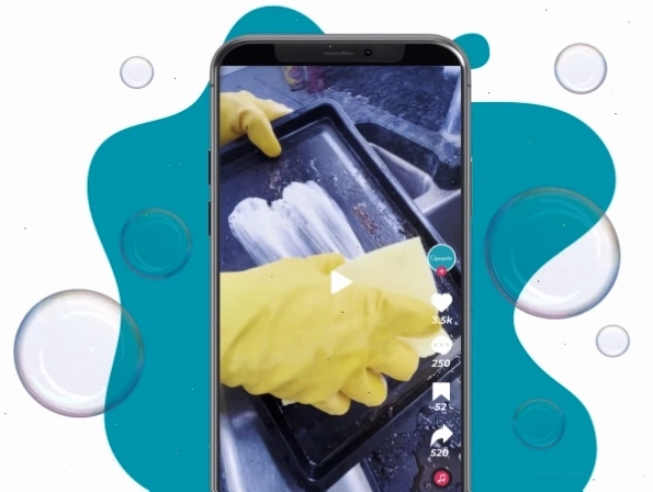 Tay đeo găng tay vàng đang vệ sinh máy may mini với dung dịch tẩy rửa
